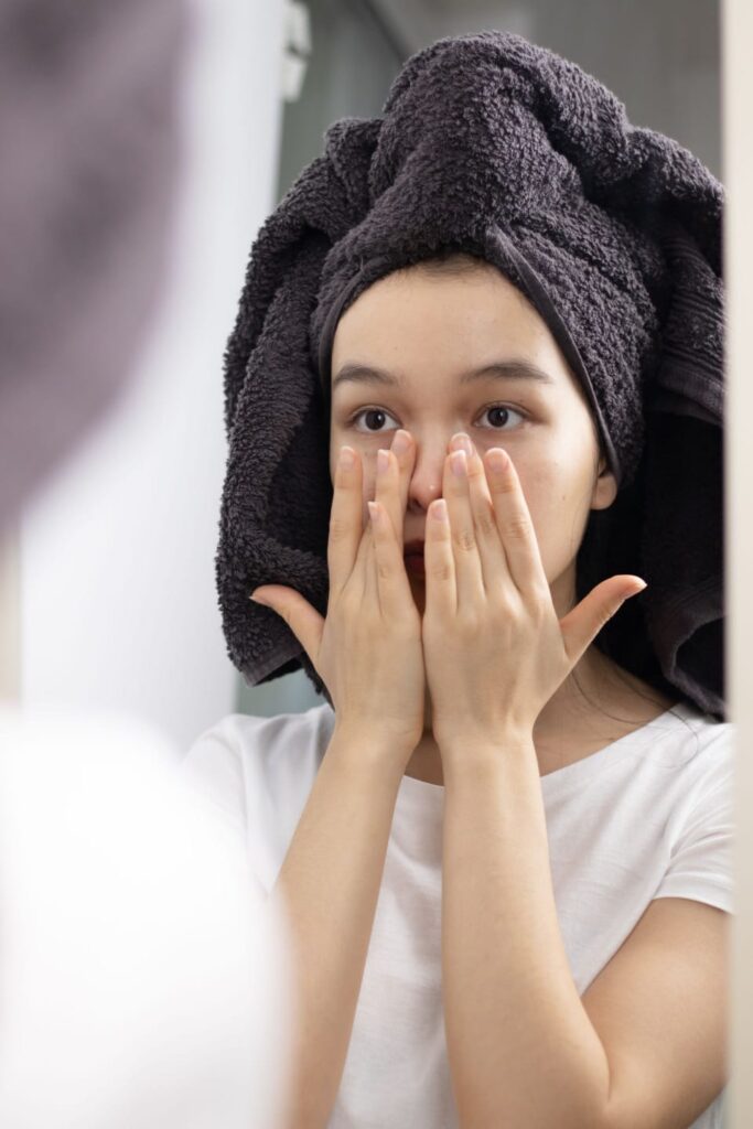 woman applying skincare product on face in the morning